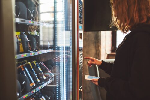 woman using vending machine that needs vending machine repair
